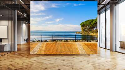 Terrace, promenade and pine trees in Bolsena lake, Italy. Wall mural