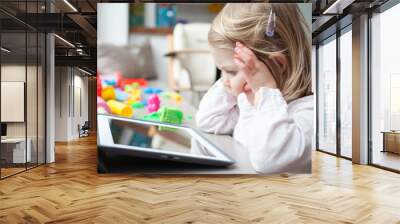 Female toddler playing on a tablet Wall mural