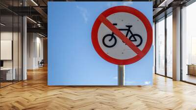 No Cycling road sign against a blue sky. Copy space on the left. Wall mural