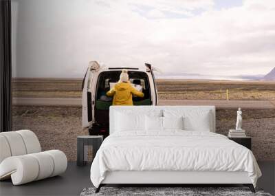 Woman looking at a map on the back of a camper van Wall mural