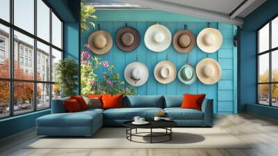 A collection of summer hats hanging on hooks at the entrance of a beach house, ready for a day outdoors   Wall mural