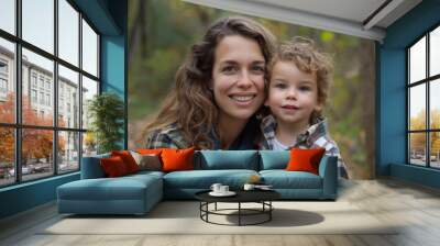 A joyful moment captured between a mother and her young child in a serene forest setting, embodying the beauty of nature and the warmth of family love Wall mural