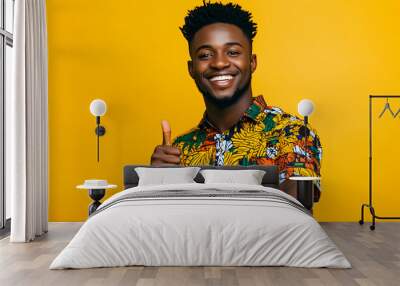 A young, cheerful African man striking a fun pose with his thumb up, in casual colorful attire   Wall mural