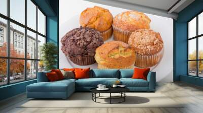 Assortment of freshly baked muffins on a white plate with isolated background Wall mural