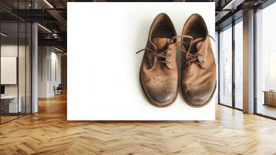 Pair of weathered brown leather shoes with laces on a plain white background, showing signs of wear and tear, highlighting ruggedness and vintage charm. Wall mural