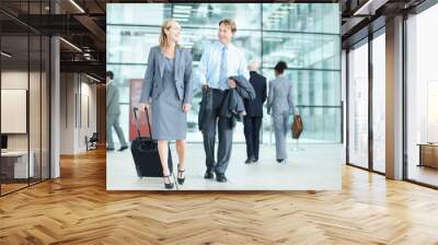 Corporate camaraderie while on the move. Laughing mature businesspeople arriving at an airport with their suitcases - Business Travel. Wall mural