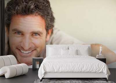 Man smiling on bed. Closeup of mature man relaxing on bed and smiling. Wall mural