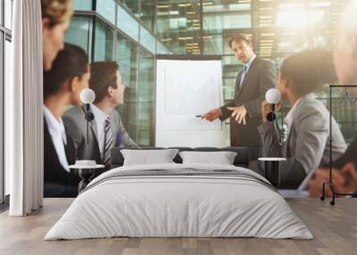 This is our new business strategy. Cropped shot of a group of businesspeople listening to a presentation. Wall mural