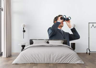 Visionary business man. Low angle view of handsome business man looking through binoculars. Wall mural