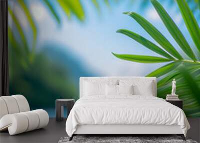 Blurred tropical beach view with palm leaves in the foreground, creating a serene and relaxing summer atmosphere in portrait format.
 Wall mural