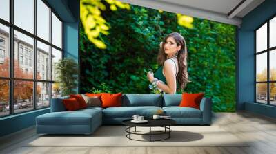 Beautiful brunette girl in glamorous green dress in nature. Ready for prom night Wall mural