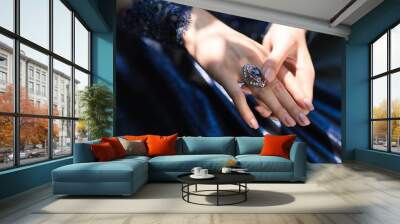 Close-up of beautiful bijou female ring with blue stone on the woman hand Wall mural