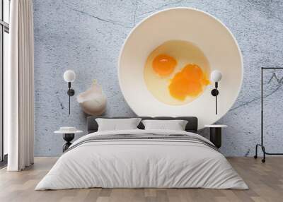 Cracked egg with two yolks inside the bowl Wall mural