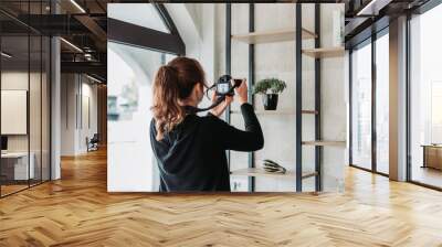 Female photographer photographing products in the office with dslr camera Wall mural