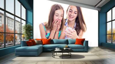 Two girls in colorful summer dresses looking at smart phone Wall mural