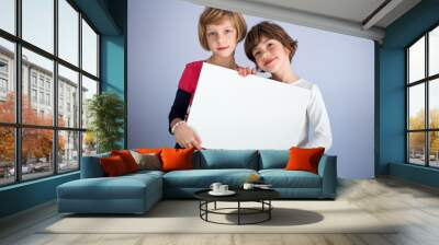 Two little girls hold empty white board. Copy space, space for writing Wall mural