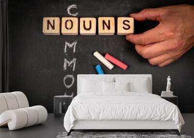 COMMON NOUNS. Wooden block crossword puzzle and pieces of chalk on a chalkboard background Wall mural