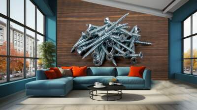 Metal screws in stack on a wooden background Wall mural