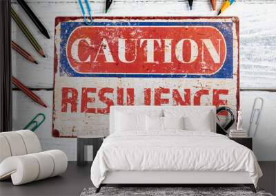 Resilience. Metal CAOTION plate with text on a white wooden background Wall mural