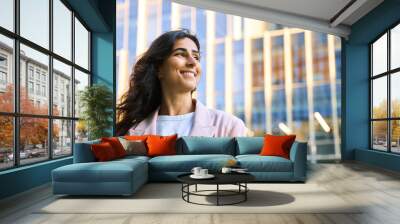 Closeup headshot outdoor portrait of young middle eastern Israel businesswoman standing office building. Successful smiling indian or arabic woman in casual business suit looking aside. Copy space Wall mural