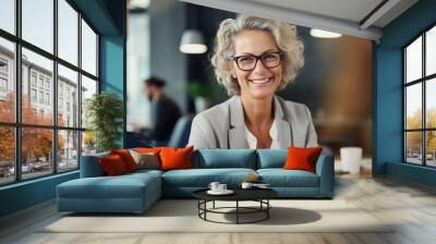 Happy mature middle 60s aged smiling lady boss manager teacher talking to assistant or student meeting in office space. Team leader portrait of company team working together in modern office. Closeup Wall mural