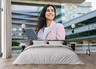 Portrait of young middle eastern Israel businesswoman using tablet pc application for work at office business building outdoors. Indian arabic woman holding digital computer, looking aside. Copy space Wall mural