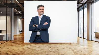 Smiling confident latin hispanic mature business man standing crossed arms isolated on white background. Older senior businessman professional ceo, coach, leader looking aside. Banner, copy space Wall mural