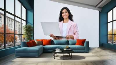 Smiling young middle eastern Israel businesswoman using laptop pc online application for work isolated on white background. Indian or arabic woman in business suit holding computer, looking at camera Wall mural