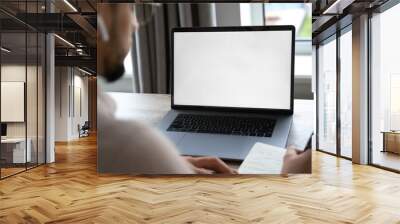 Young man working on laptop with blank copy space screen from home office Wall mural