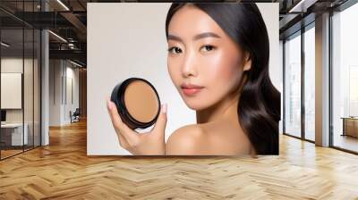 A model showcases a creamy foundation product, highlighting beauty and skincare essentials for a flawless complexion. Wall mural