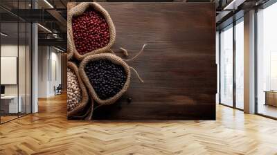 Assorted legumes in burlap sacks arranged on wooden table surface Wall mural