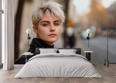 Young woman with short hair poses confidently on city street at dusk, copy space for text Wall mural