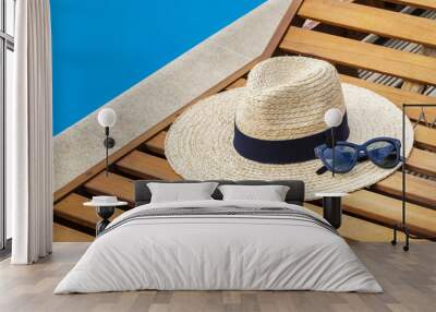 Straw hat with sunglasses near swimming pool Wall mural