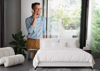 Smiling man talking on mobile phone Wall mural