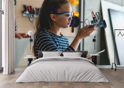 Young girl working on school assignment Wall mural