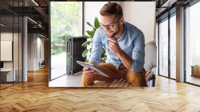 Young Man looking at digital tablet Wall mural