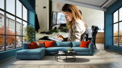 Young woman working in her office Wall mural