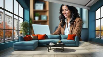 Busy young business woman executive using laptop in office. Smiling Hispanic businesswoman company employee sitting at work desk, professional female hr manager looking at pc computer at workplace Wall mural