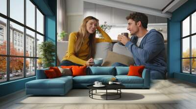 Chatting duet drinking tea at sofa interior closeup. Woman listening husband Wall mural