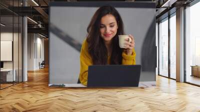 Closeup business woman looking laptop. Smiling girl drinking tea near notebook Wall mural