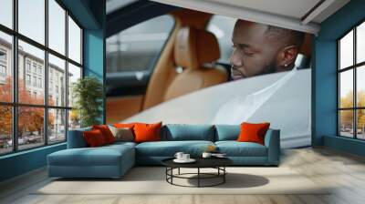 Closeup businessman looking at camera at car. African man smiling in luxury car Wall mural