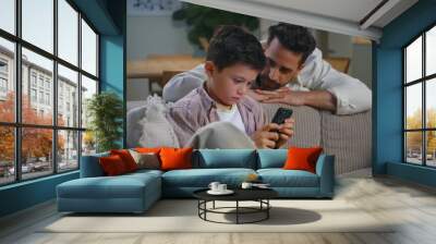 Daddy talking online son at evening apartment closeup. Internet addicted kid Wall mural