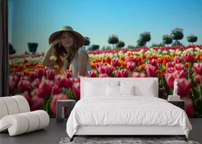 Relaxed woman sitting in beautiful spring garden. View of blooming tulip field.  Wall mural