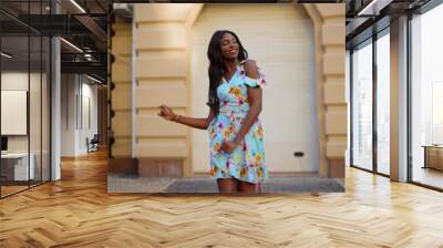 Smiling afro girl dancing bachata in dress in city. Woman dancing latino dance Wall mural