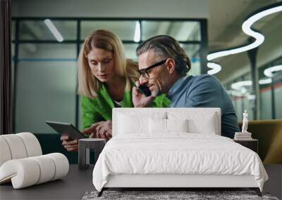 Two colleagues working together office. Woman consulting with calling phone man Wall mural