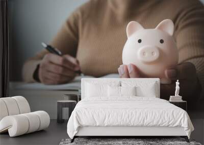 Woman save money for household expenses in piggy bank Wall mural