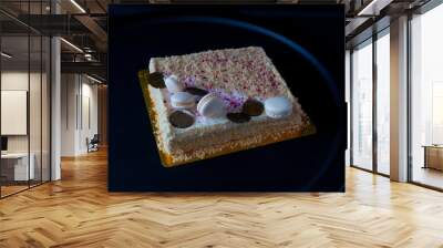 cake with macaroons with colored crumbs on a round black dish, on a dark background. Copy space. on a dark background Wall mural