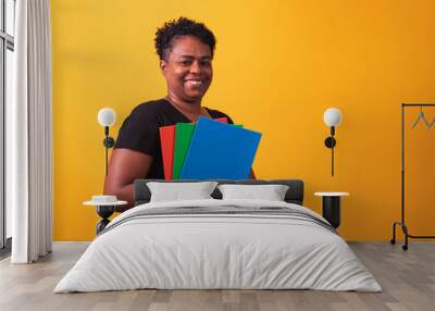 Mature student woman smiling looking at camera with space for text on yellow background. Mature black student woman Wall mural