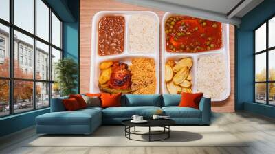 Two delicious lunchboxes or lunchboxes, lunchbox, served with rice, rustic potatoes, french fries parmigiana fillet, and another with chicken, beans and manioc flour with wooden background, top view Wall mural