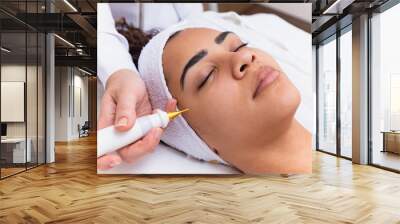 Woman doing facial treatment with plasma jet in beauty clinic. Wall mural